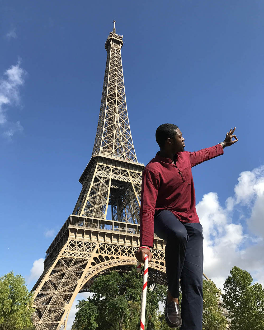 pqc male student in france posing in front of the Eiffel Tower